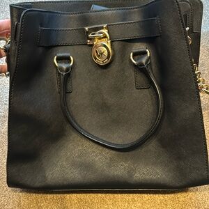 Hardly used black Michael Kors purse with gold chain. Very clean no stains.